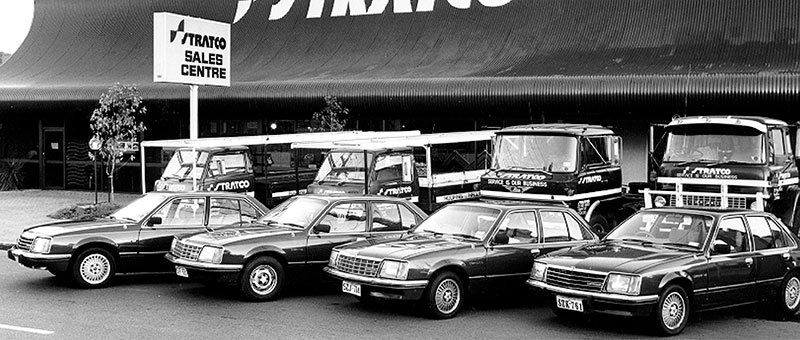 Stratco Sales Centre Stratco Sales Centre with vintage delivery trucks and cars parked in front